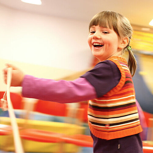 Kind tanzt ausgelassen im Turnraum