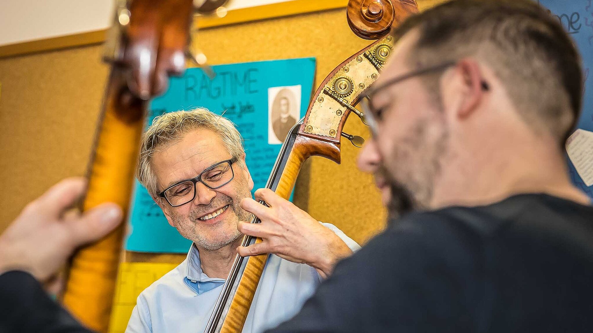 Nahaufnahme eines Kontrabass-Lehers und des erwachsenen Schülers im Unterricht