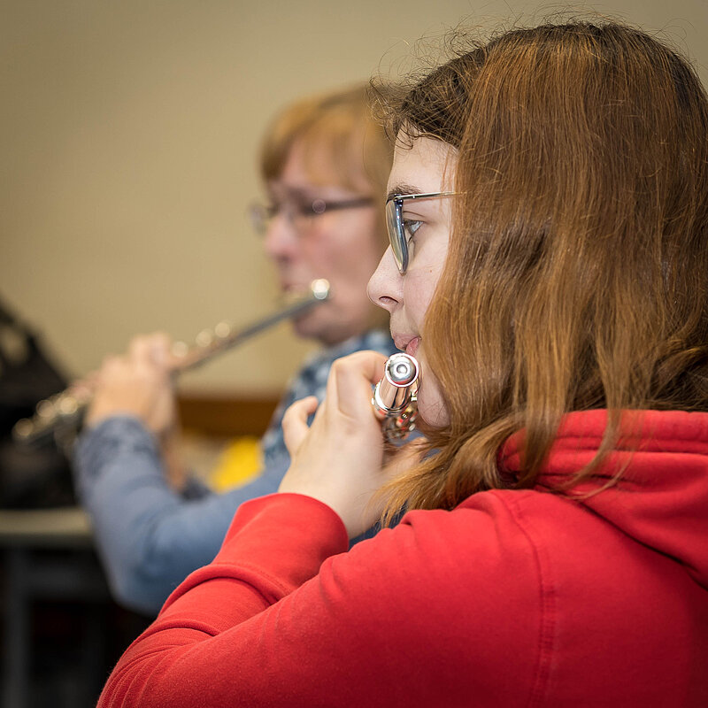 Eine jugendliche und eine erwachsene Querflötistin während der Probe