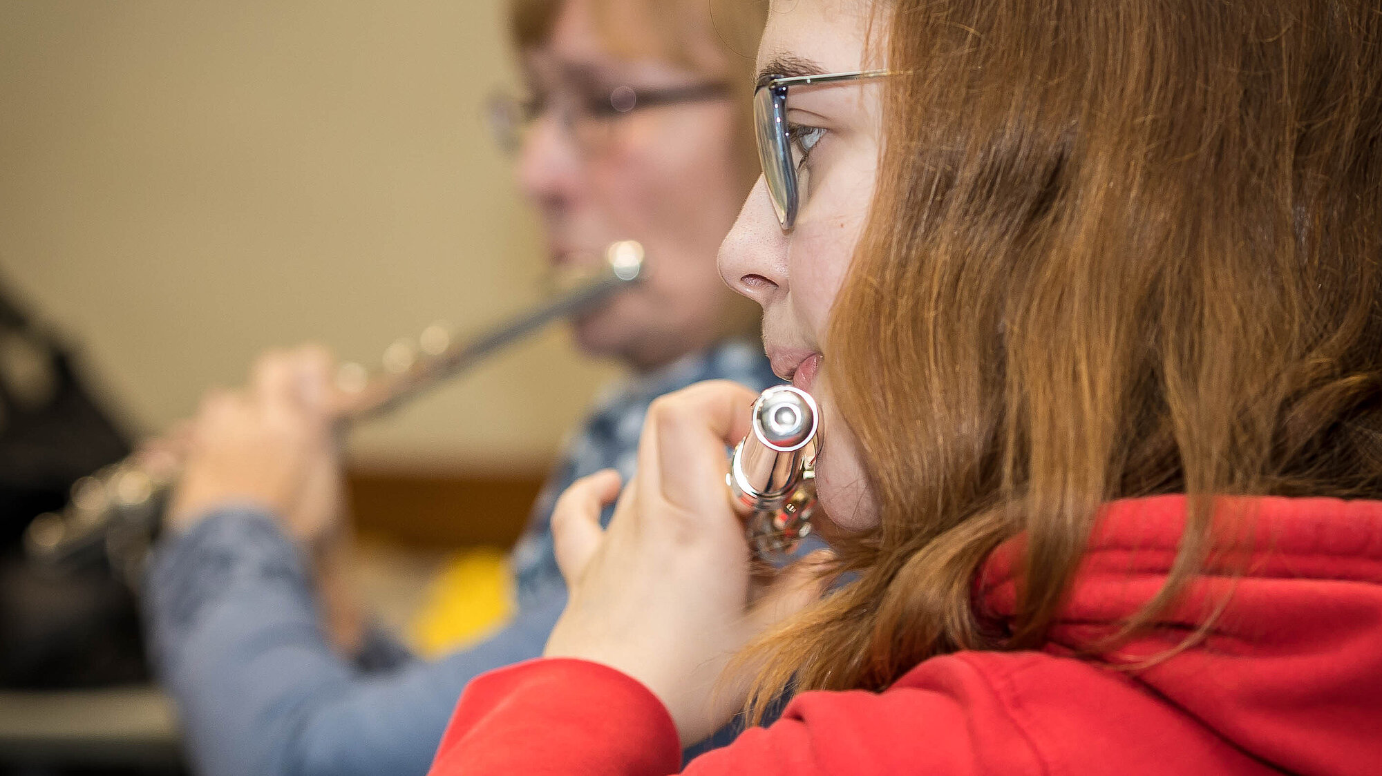 Eine jugendliche und eine erwachsene Querflötenspielerin während der Probe.