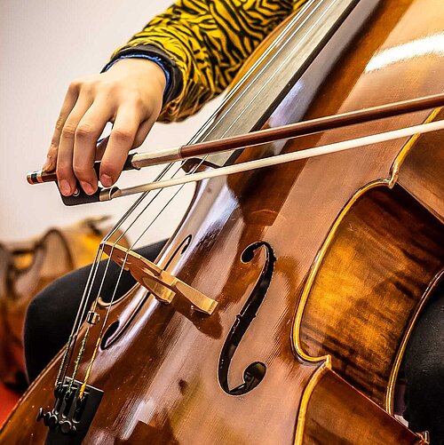 Jugendliche spielt auf einem Cello, Detailfoto des Cellokorpus