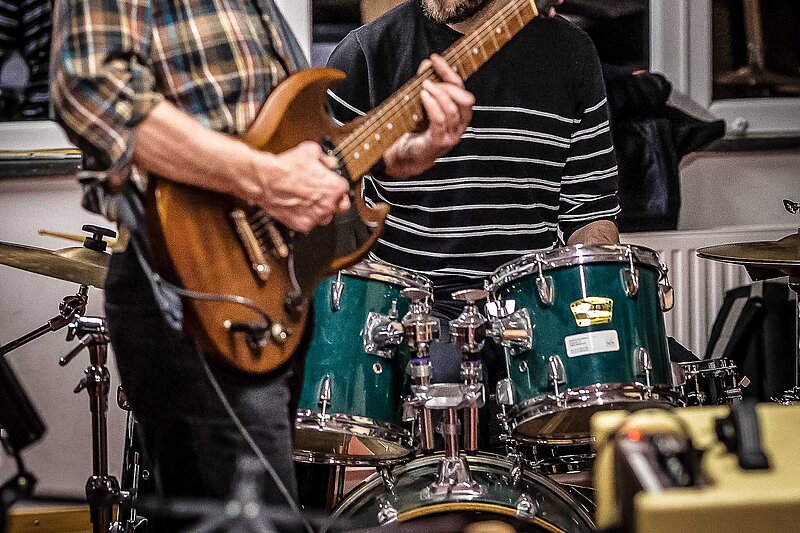 E-Gitarrist und Drummer bei einer Rockbandprobe